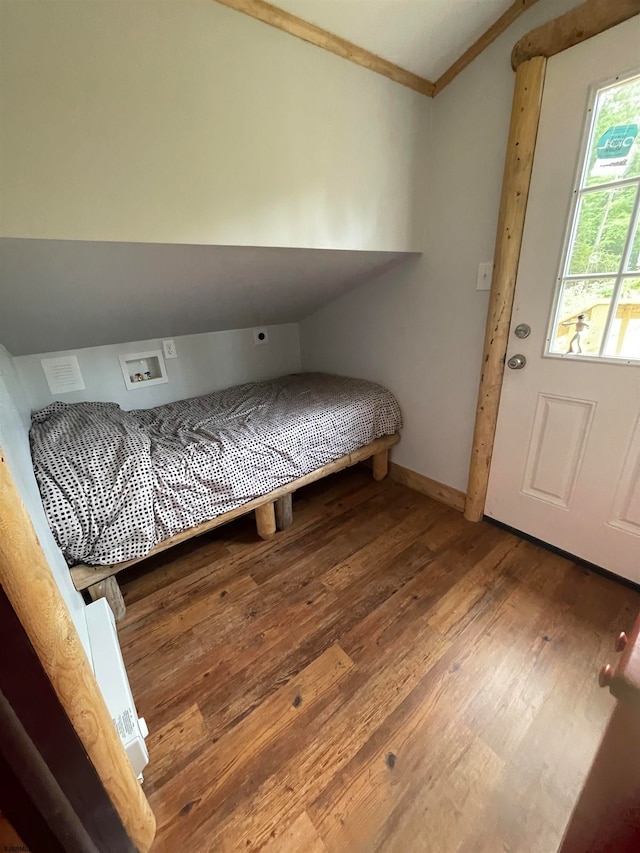 interior space featuring wood-type flooring, crown molding, and vaulted ceiling