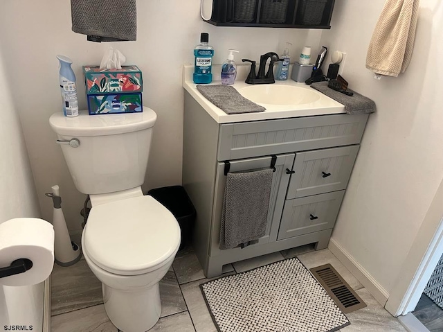 bathroom featuring vanity, tile patterned flooring, and toilet