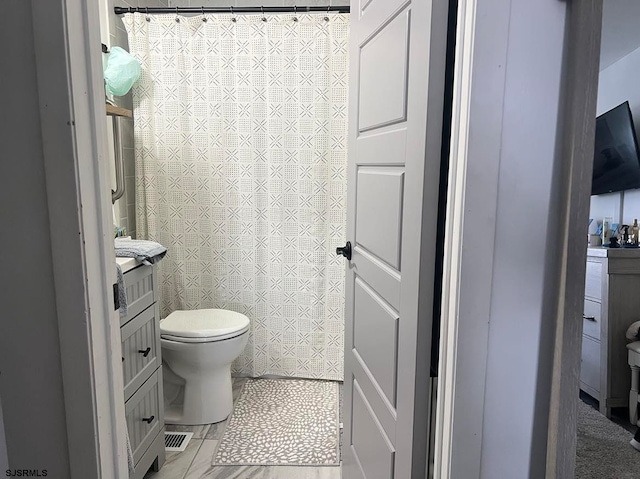 bathroom featuring tile patterned flooring, toilet, and vanity