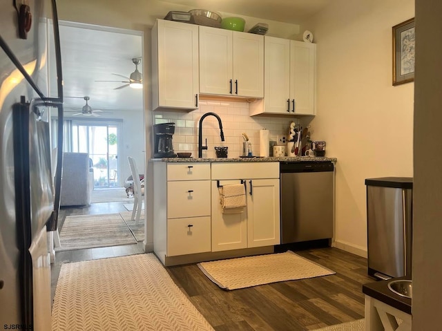 kitchen with ceiling fan, stainless steel appliances, dark hardwood / wood-style flooring, white cabinets, and dark stone countertops