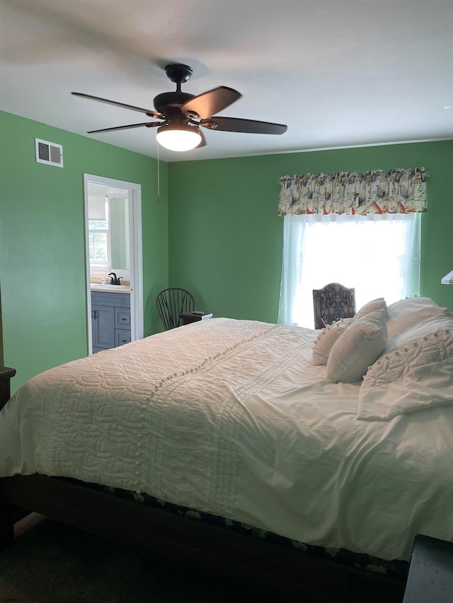 bedroom featuring ensuite bath, sink, and ceiling fan