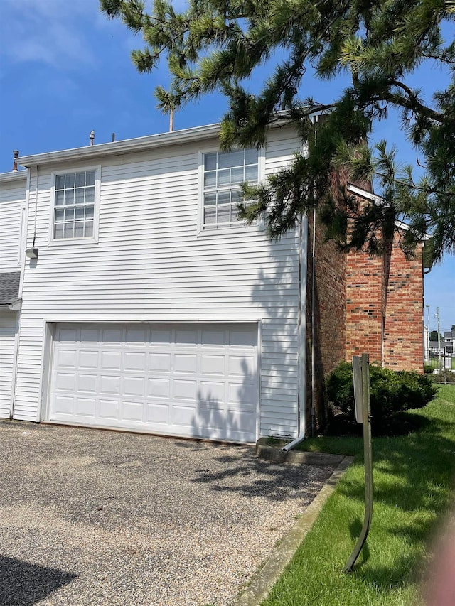 view of property exterior with a garage and a lawn