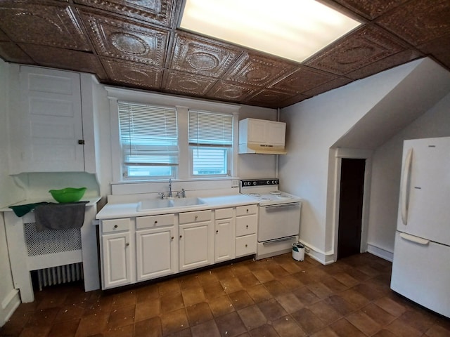 kitchen with dark tile patterned floors, white cabinetry, white appliances, and sink