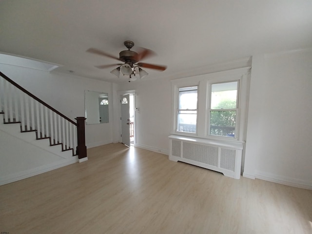 foyer with radiator heating unit, light hardwood / wood-style flooring, and ceiling fan