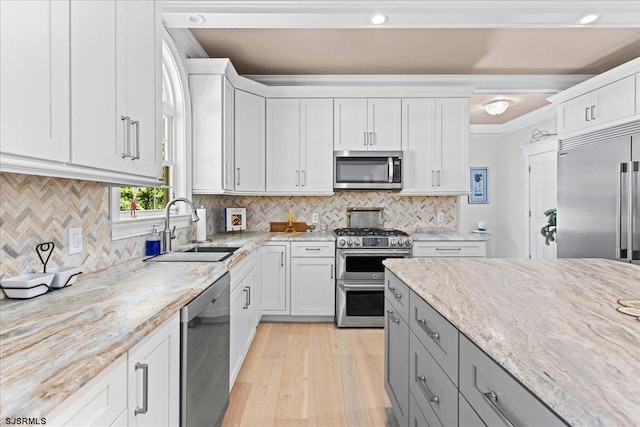 kitchen with crown molding, tasteful backsplash, high quality appliances, and white cabinetry