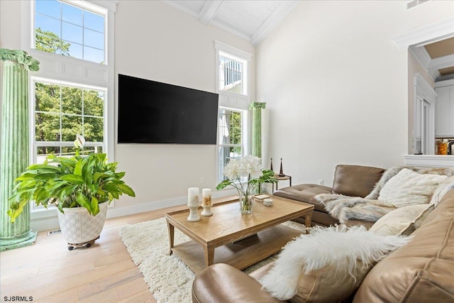 living room with beam ceiling, high vaulted ceiling, light wood-type flooring, and a wealth of natural light