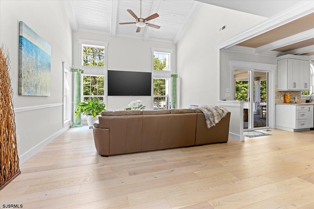 living room with ceiling fan, ornamental molding, beam ceiling, and light hardwood / wood-style floors