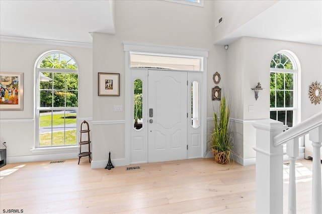 entrance foyer featuring crown molding and light hardwood / wood-style flooring