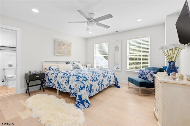 bedroom featuring ceiling fan, light hardwood / wood-style flooring, and connected bathroom