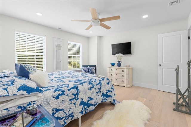 bedroom with light hardwood / wood-style floors, ceiling fan, and multiple windows