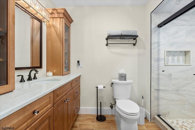 bathroom featuring a shower with door, toilet, vanity, and wood-type flooring