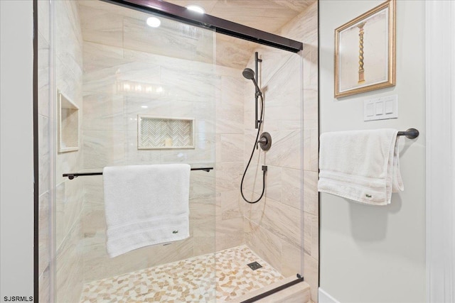 bathroom featuring a shower with door