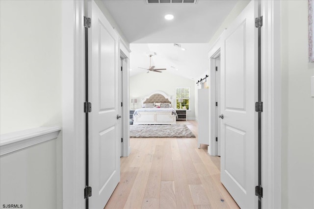 hall featuring light hardwood / wood-style flooring and lofted ceiling