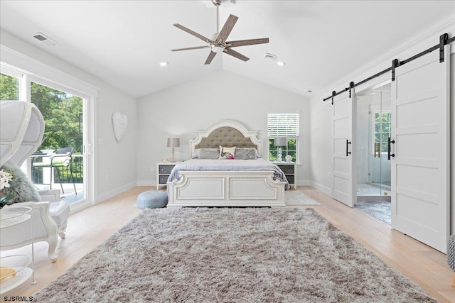 bedroom with ceiling fan, light hardwood / wood-style flooring, a barn door, and access to exterior