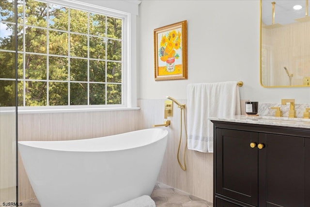 bathroom with tile patterned floors, vanity, and a healthy amount of sunlight