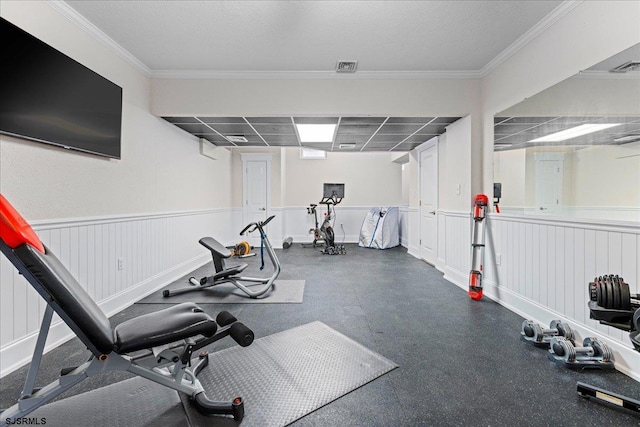 exercise area with a paneled ceiling and ornamental molding