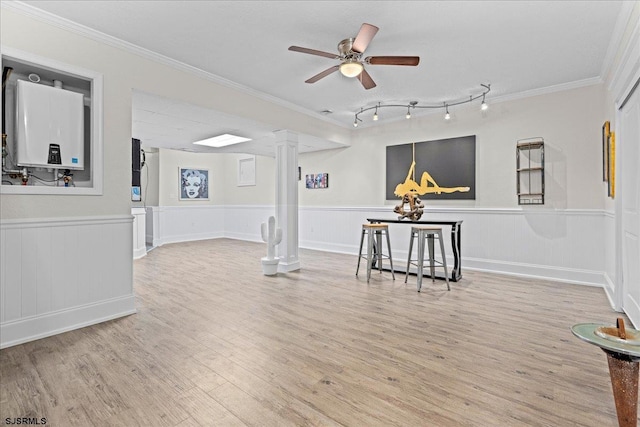 living room featuring ornate columns, track lighting, ceiling fan, and light hardwood / wood-style floors