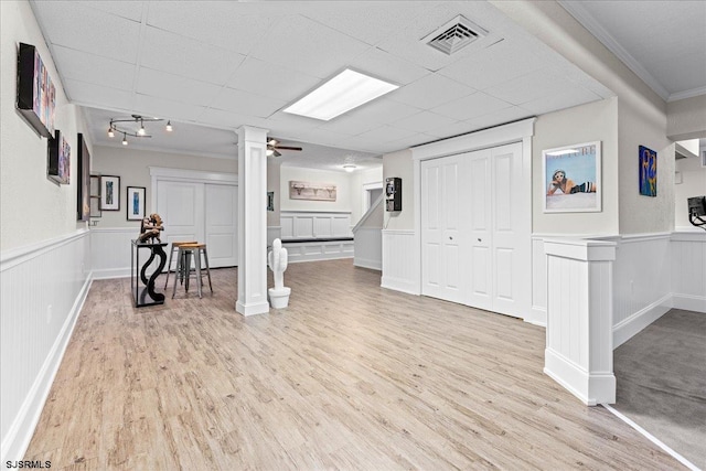 basement featuring ornamental molding, ceiling fan, and light hardwood / wood-style floors