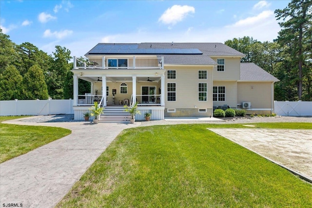 view of front of home with a front yard, solar panels, a balcony, and a porch