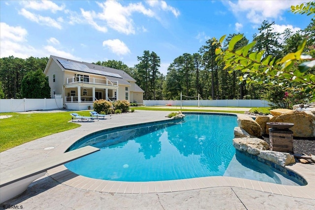 view of pool with a lawn and a diving board