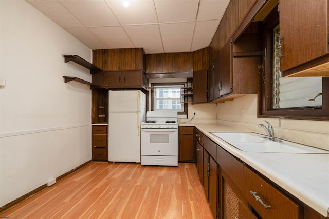 kitchen with white appliances, light hardwood / wood-style floors, sink, and a paneled ceiling