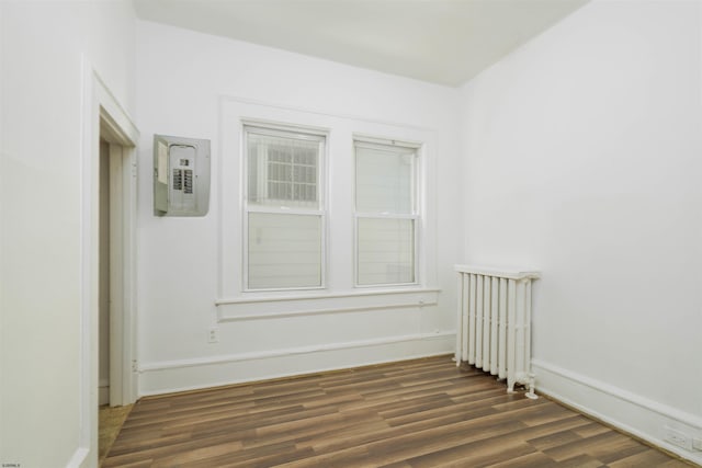 unfurnished room with dark wood-type flooring and radiator heating unit