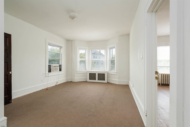 spare room with carpet floors and radiator heating unit