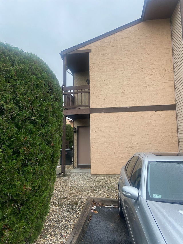 view of home's exterior featuring a balcony and central AC