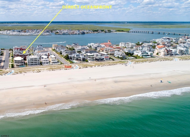 birds eye view of property with a water view and a beach view