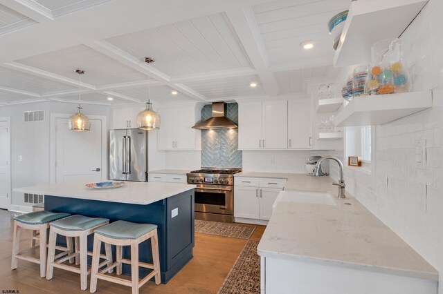 kitchen featuring tasteful backsplash, stainless steel appliances, white cabinets, sink, and wall chimney range hood