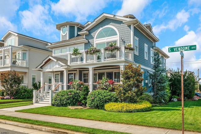 view of front facade with a front yard and a balcony