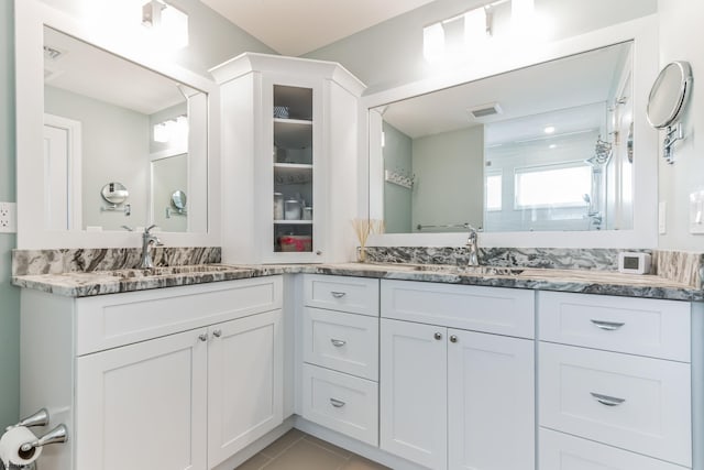 bathroom with tile patterned floors and dual bowl vanity