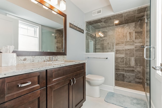 bathroom featuring toilet, tile patterned floors, vanity, and an enclosed shower