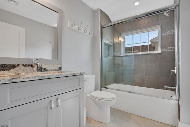 full bathroom featuring toilet, tile patterned floors, vanity, and bath / shower combo with glass door