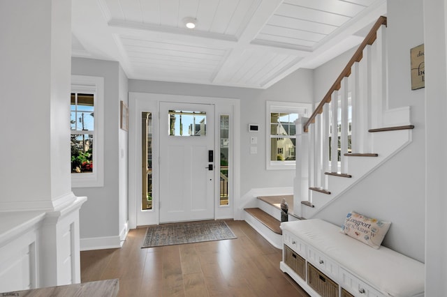 foyer entrance featuring beamed ceiling, dark hardwood / wood-style flooring, and a healthy amount of sunlight