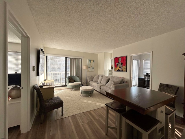 dining space with hardwood / wood-style flooring and a textured ceiling