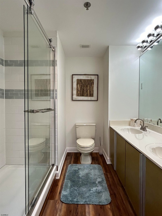 bathroom with dual vanity, toilet, and hardwood / wood-style floors