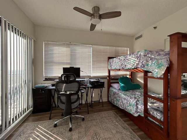 bedroom featuring hardwood / wood-style floors, a textured ceiling, and ceiling fan