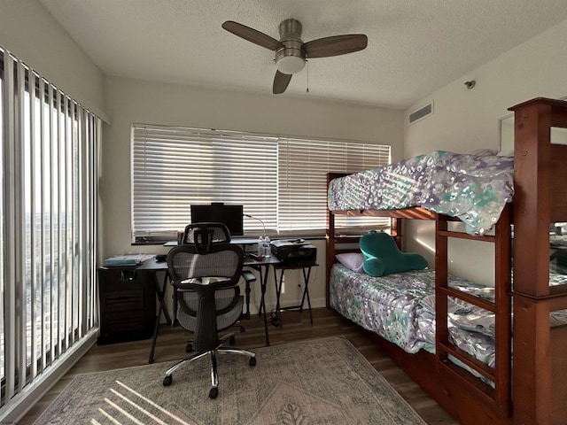 bedroom featuring visible vents, ceiling fan, a textured ceiling, and wood finished floors