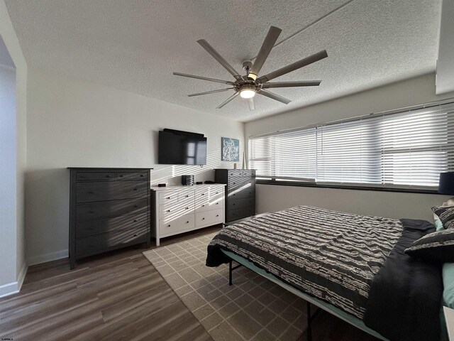 bedroom with ceiling fan, hardwood / wood-style flooring, and a textured ceiling