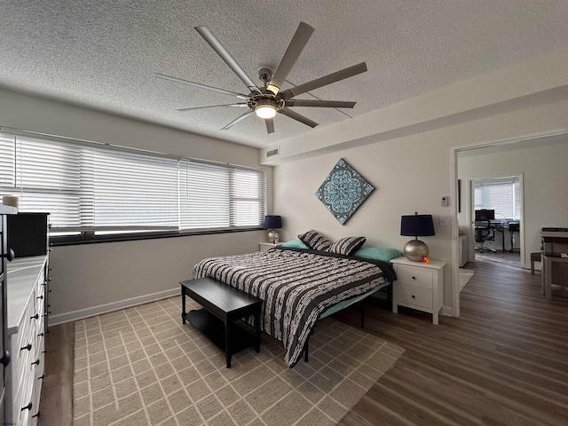 bedroom featuring ceiling fan, wood-type flooring, and a textured ceiling