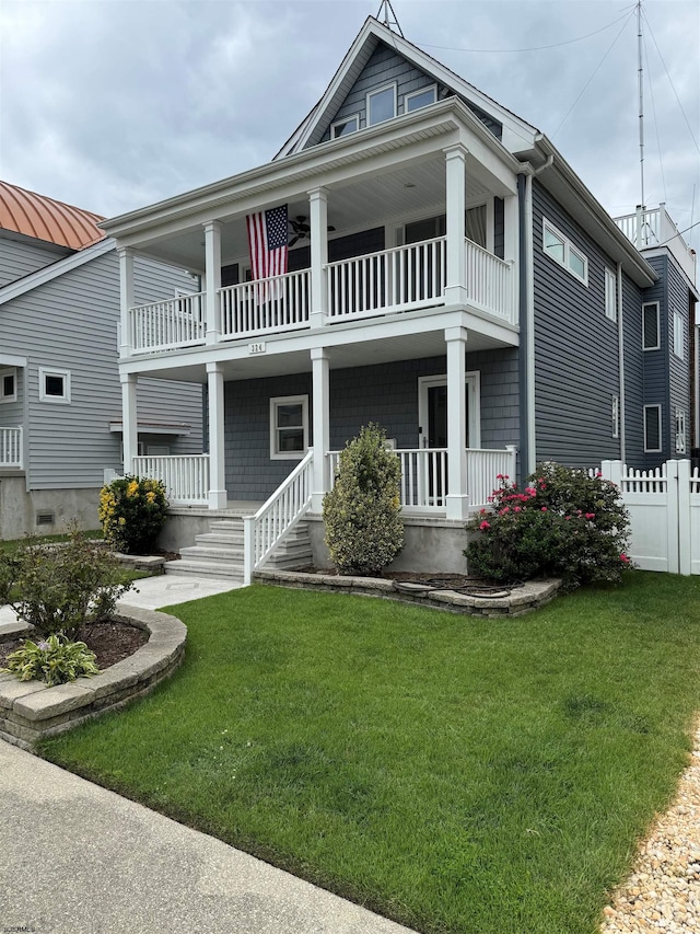 view of front facade with a balcony, covered porch, and a front lawn