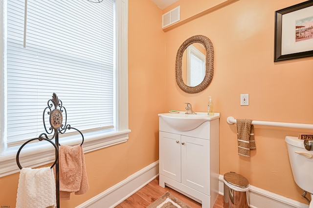 bathroom featuring vanity, toilet, and hardwood / wood-style floors