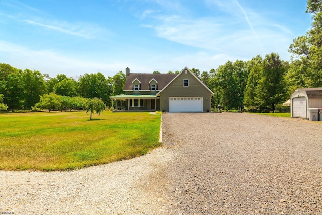 view of front of house with a garage, a chimney, covered porch, and a front yard