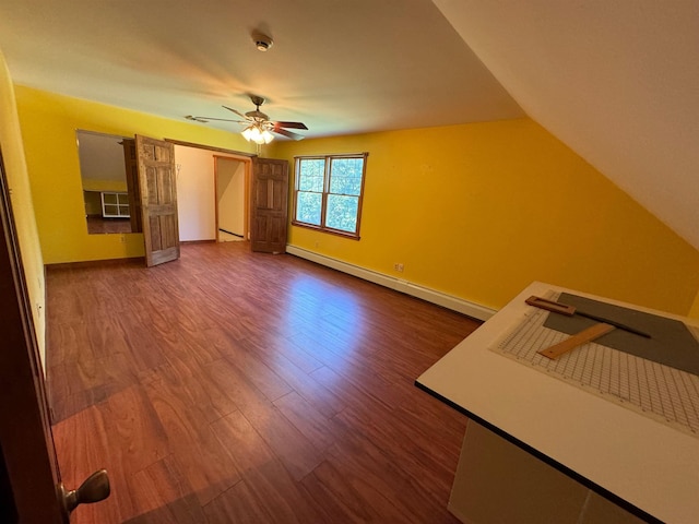 bonus room featuring baseboards, ceiling fan, dark wood-type flooring, vaulted ceiling, and a baseboard heating unit