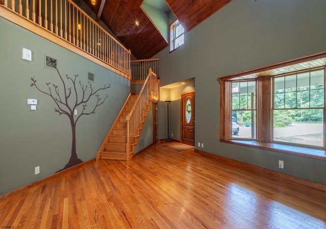 unfurnished living room with stairs, visible vents, wood finished floors, and wooden ceiling