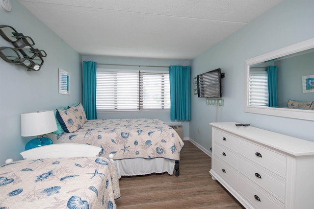 bedroom with dark hardwood / wood-style flooring