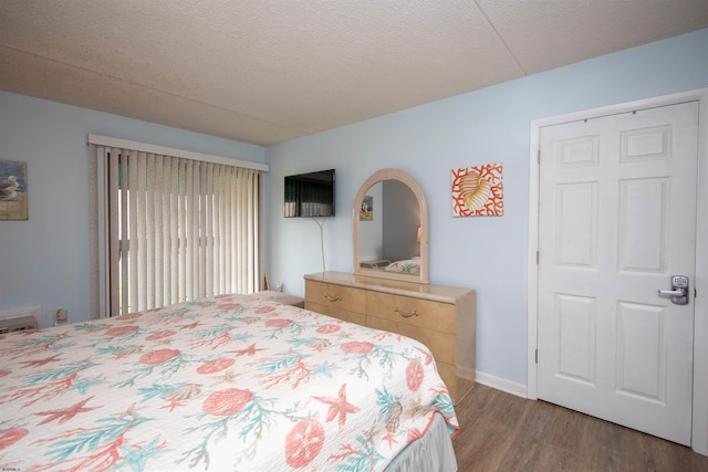 bedroom with a textured ceiling and wood-type flooring