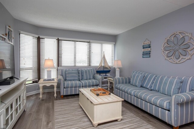 sitting room with stacked washer and clothes dryer, a textured ceiling, and dark hardwood / wood-style flooring