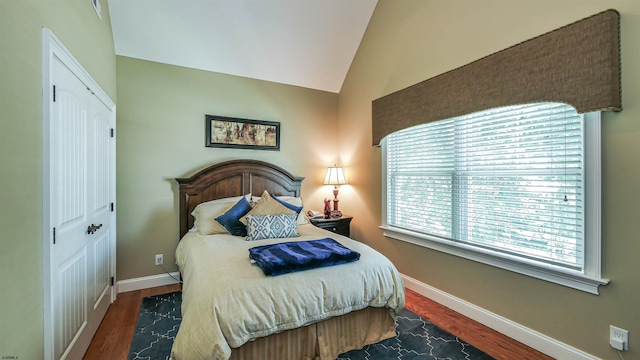 bedroom featuring dark hardwood / wood-style floors, a closet, and lofted ceiling